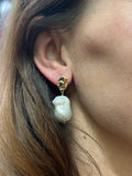 Close-up of an ear wearing a Designer Adrian Hailwood gold and pearl earring.