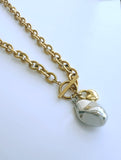 Designer Adrian Hailwood Gold chain necklace with a silver teardrop pendant on a white background