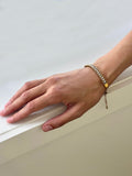 Hand wearing fashion designer Adrian Hailwood  bracelet on a light background